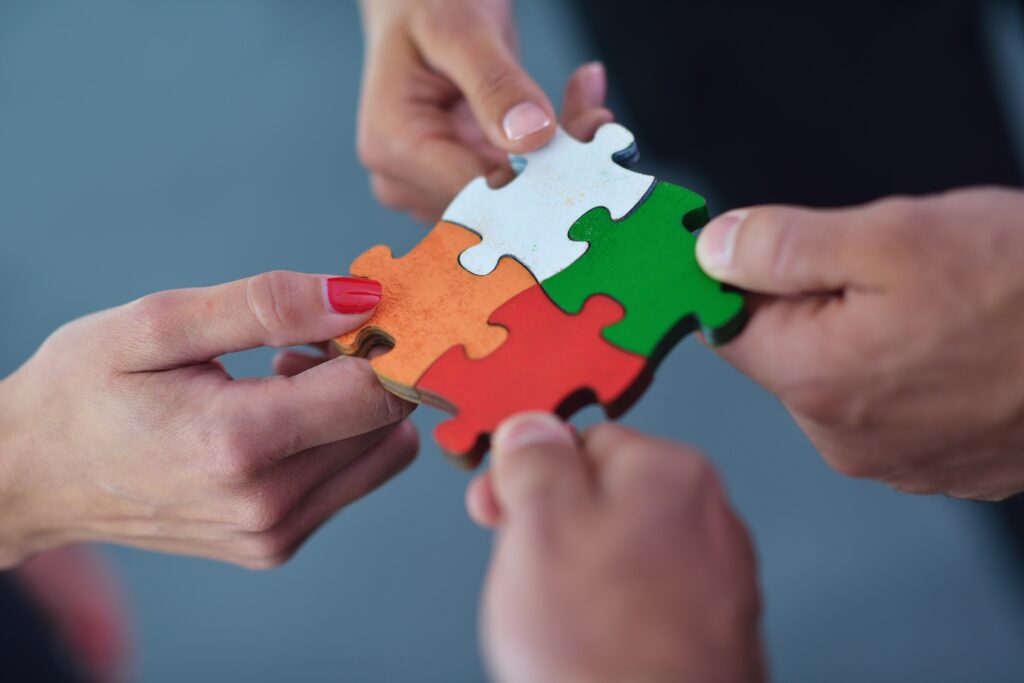group of business people assembling jigsaw puzzle